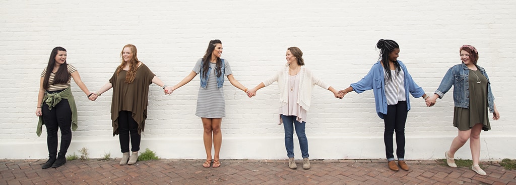 Image of Girls Holding Hands Outside Brick Wall - Oasis Pregnancy Care Centers Tampa